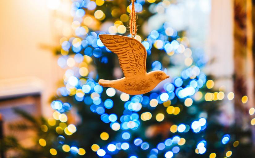 Christmas dove ornament with Christmas tree in background